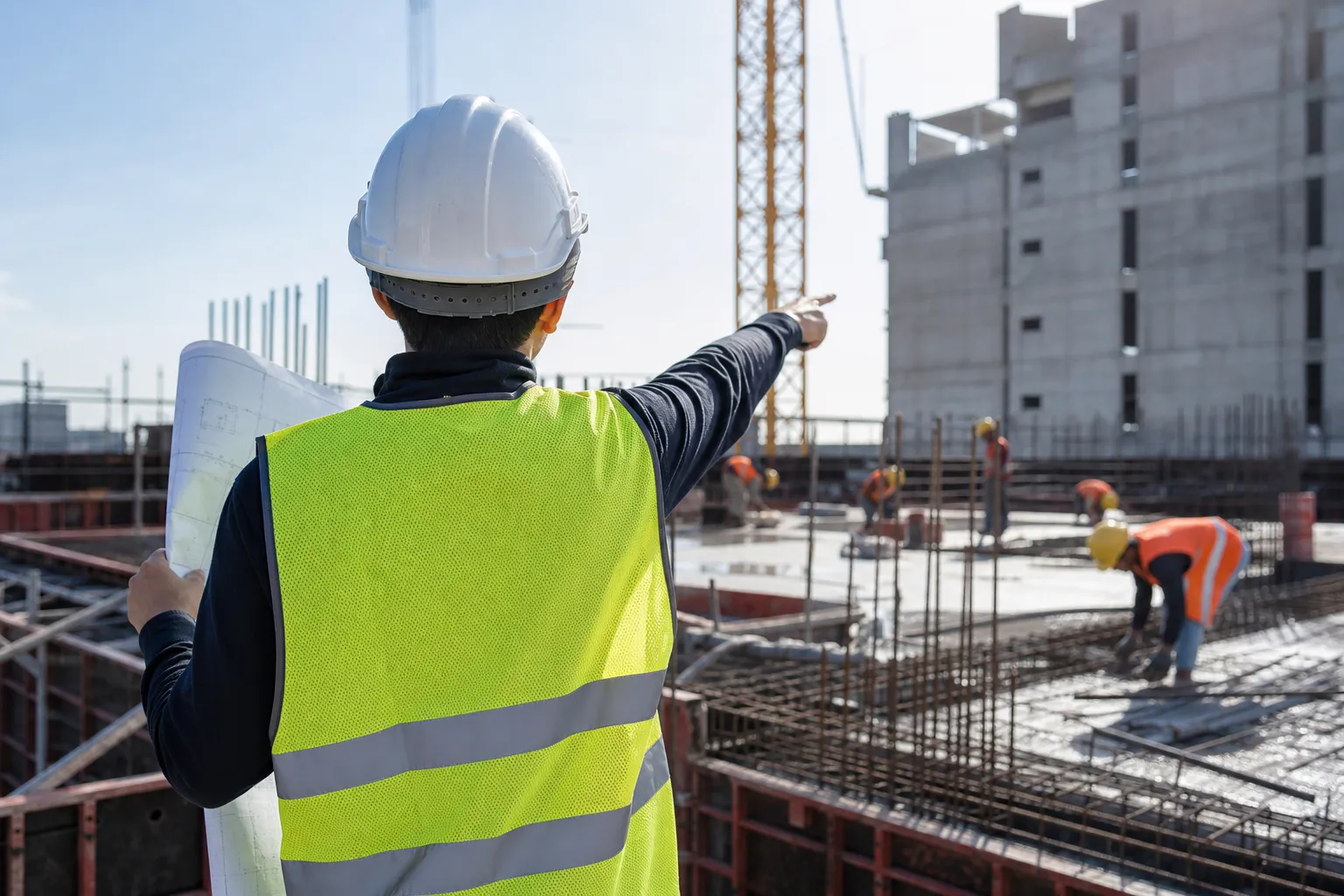 現場で職人に段取りを指示する施工管理者